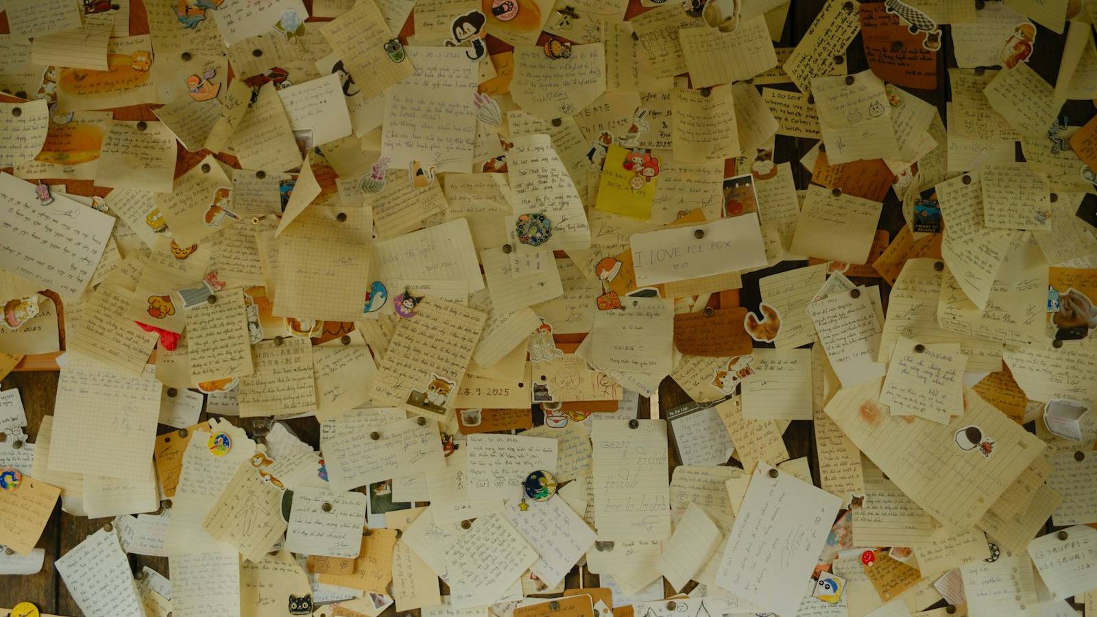 A wall covered with handwritten notes and cards pinned up